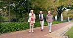 Senior friends, walking and talking together on an outdoor path to relax in nature with elderly women in retirement. People, happy conversation and healthy exercise in the park in autumn or winter