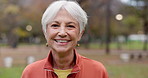 Senior woman with a smile, portrait in the park and happiness in nature, woods or outdoor for a walk in retirement. Happy, face and elderly person with wellness from exercise or healthy workout