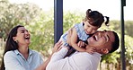 Happy, love and parents playing with their baby in the backyard garden of their family home. Happiness, smile and young mother and father bonding with their girl infant child outdoor at their house.