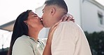 Happy, couple and kiss outdoor for love, affection or bonding together. Man, woman and smile in intimate moment, romance and trust for support, commitment and marriage for loyalty in partnership