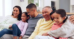 Funny children, parents and grandparents on a sofa in the living room together during a visit for bonding. Comic, comedy or happy kids with family, laughing in their home for love, humor or joking