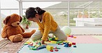 Girl child, building blocks and learning on floor, thinking and development for problem solving skills at kindergarten. Young kid, toys and education for mindset, focus and progress with brain power