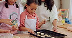 Grandma, mom and kids learning baking in a home kitchen counter together to prepare dessert as a skill or care. Family, mother and girls teaching or helping children with a cookies recipe or food