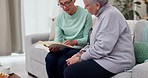 Senior, reading and women with a book on the sofa for education, learning and studying for knowledge. Relax, elderly friends and a story for retirement literature together in a nursing home lounge