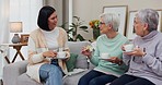 Talking, senior friends and tea on the sofa for relax, conversation and nursing home visit. Happy, living room and a woman speaking to elderly people with coffee on the couch for company and care