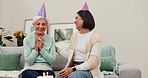 Elderly mom, woman and wish happy birthday with smile, gratitude and cake with party, care and bonding. Celebration, senior mother and daughter for event, candle or motivation on sofa in family house