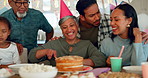 Birthday, party and a senior woman with her family at home together in celebration of a life milestone event. Kids, parents and grandparents with cake in a house to celebrate an elderly grandma