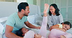 Tickle, morning and happy with family in bedroom for playful, relax and wake up. Smile, happiness and support with parents and children in bed at home for love, care and bonding together