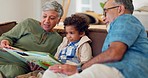 Grandparents, child and reading books on sofa for learning, language development or care in lounge. Grandmother, grandfather and boy kid relax in quality time, storytelling or together in family home