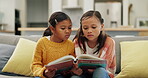 Education, sisters and reading a book on sofa for knowledge in home with fantasy in home. Children, learning and couch for knowledge or story telling for literature with laughter or love on weekend.