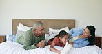 Happy, family and parents with teddy bear in bedroom, bonding and having fun together. Father, mother and girl with stuffed animal, toys and smile, play and enjoying quality time on bed in house