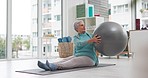 Senior woman stretching with ball for exercise, wellness and workout in retirement in yoga studio. Old lady, twist movement and mobility with fitness equipment on floor, mat and care of healthy body