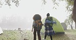 Woman, hiking and walking with back, camping and woods with backpack, partnership and navigation. Girl friends, nature and travel in fog, outdoor or forest for adventure, holiday or vacation together