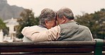 Love, affection and senior couple on a bench hugging for a connection, commitment or care in a garden. Nature, happy and elderly man and woman in retirement embracing for an intimate moment in a park