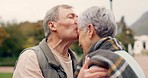 Forehead, kiss and senior couple in a park with love, happy and conversation with romantic bonding. Kissing, old people and elderly man embrace woman with care, romance or soulmate connection outdoor