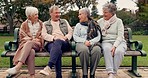 Conversation, nature and mature friends in a park sitting on bench for fresh air together. Happy, smile and group of senior people in retirement in discussion or talking in an outdoor green garden.