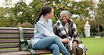 Nurse, happy and talking with old woman on park bench for retirement, elderly care and conversation. Trust, medical and healthcare with african patient and caregiver in nature for rehabilitation