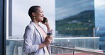 Business woman, phone call and talking on terrace at office building for networking or negotiation. Black female entrepreneur outdoor for smartphone conversation with coffee, communication and laugh