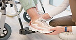 Caregiver, help and senior woman in wheelchair with shoes in closeup for comfort, care. Nurse, hand and sneakers for elderly person with disability in retirement home for support with medical worker.