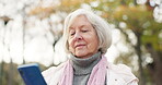 Phone, social media and a senior woman in the park, typing or reading a text message for communication. Mobile, contact and sms with a happy elderly female person walking in an outdoor garden