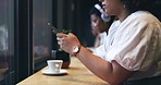 Cafe, phone and closeup of a woman typing a text message on the internet or social media. Technology, cup of coffee and young female person doing research or browsing on her cellphone in a restaurant