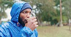 Camping, morning and a black man drinking coffee in winter while outdoor in nature to relax. Hiking, rain and a young male tourist in the forest or woods for travel and freedom with a cup of tea