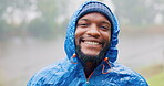 Face, smile and a black man hiking in the rain, outdoor in nature for travel, tourism or adventure. Portrait, winter and wet with a happy young hiker in the forest or woods for freedom and vacation