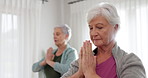 Senior woman, yoga and meditation in class for spiritual wellness, zen exercise or workout together at home. Calm elderly women or yogi in fitness or namaste pose for awareness or inner peace indoors