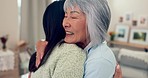 Family, smile and a senior asian woman hugging her daughter in the living room of a home during a visit. Love, retirement and an adult child embracing her happy mother together in an apartment