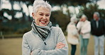 Face, senior woman and arms crossed in nature on vacation, holiday or travel in winter. Portrait, happy and elderly person in the countryside, park or garden with confidence for freedom in retirement