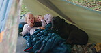 Camp, phone and children in a tent outdoor in nature with internet connection for streaming online. Kids, friends and family dog watch a movie, video or playing games on smartphone on camping holiday