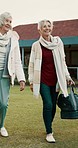 Retirement, talking and senior woman friends walking on a field at the bowls club together for a leisure activity. Smile, hobby and elderly people on the green of a course for bonding or recreation