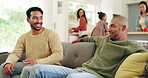 Friends, couch and men talking in a family home in conversation in a living room together at a gathering. Discussion, father and people speaking in a lounge for communication laughing in happiness