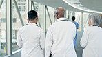 Teamwork, walking or doctors speaking of results or healthcare paperwork in a hospital clinic. Documents, back view or surgeons speaking of cardiology news report, medical feedback or research data