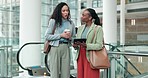 Tablet, planning and business women in the office for a collaboration project by the escalator. Discussion, online and professional female employees or friends doing research on digital technology.