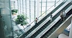 Escalator, travel and professional business people in an office building or convention center. Waiting, entrance and corporate employees standing on moving stairs in an airport or workplace in city.