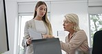 Discussion, document and manager helping a businesswoman with a project in the office. Conversation, collaboration and senior female leader talking to young colleague with paperwork in the workplace.