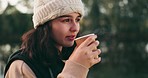 Face, smile and hiking with a woman drinking coffee outdoor while in nature for travel, freedom or adventure. Happy, camping and vacation with a young female hiker in the forest or woods closeup