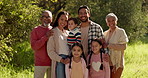 Face, big family and happy in park on vacation, holiday or travel outdoors to bond together in nature. Interracial, grandparents and parents with children in forest, woods or countryside in portrait
