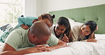 Mother, father and children together on a bed in the morning for love, care or bonding in the home. Smile, happy or funny with a man, woman and kids laughing in a bedroom while playing or having fun