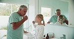 Grandfather, grandchild and brushing teeth, hygiene and dental, morning routine in bathroom and mirror. Toothbrush, cleaning mouth and grooming, old man and young girl at home, health and bonding