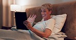 Senior woman, tablet and video call in bedroom at night with voip communication, social network or chat at home. Happy lady wave hello on digital technology for virtual conversation online in evening