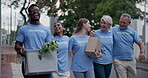 City volunteer, walking and happy people hug, talking and bond after donation, charity work or community service project. Solidarity, NGO friends and urban volunteering group embrace for support care