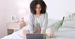 Blog writer typing with laptop for internet website and reading funny social media post on bed in home. Woman freelance worker in bedroom working remote while writing funny or comic web content