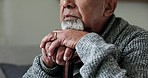 Hands, closeup and a senior man with a cane, depression and sad in a retirement home. Anxiety, mental health and an elderly person with a walking stick in a house with a problem or lonely in a house