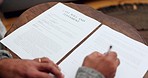 Hands, writing and will documents on table, planning and financial guide for future, death and property in home. Person, paperwork and compliance with legal review, decision and signature for deal 