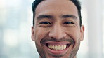 Face, smile and closeup with a business man looking proud, confident or positive about life in his office. Portrait, happy and a young male professional employee in the workplace for career success
