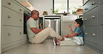 Father, son and games on the kitchen floor with a family in their home together friendly competition. Kids, love and and a man playing with his young child while having fun or laughing while bonding