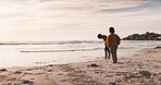 Beach, travel and boy children playing in the ocean while on a tropical vacation, adventure or holiday. Playful, exploring and young kids having fun by seaside in the sand at sunset on a weekend trip