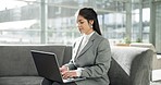 Laptop, couch and woman in office lobby typing email, networking report or online research. Smile, internet and businesswoman on couch in business lounge with computer checking on review or feedback.